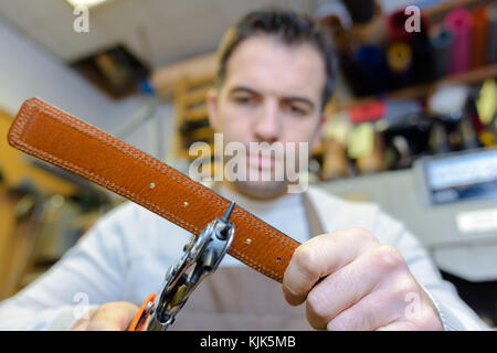 Man making belts Banque D'Images