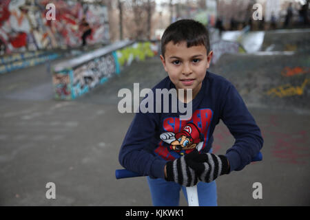 10-year-old boy riding a scooter dans un skate park France. Banque D'Images