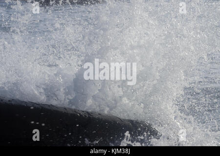 De nombreuses gouttes d'eau à partir d'une onde de tempête dans la mer bat contre une pierre énorme Banque D'Images