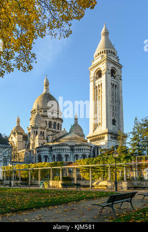 Les trois-quarts vue arrière de la Basilique du Sacré Coeur de Paris au lever du soleil en automne vu à partir d'un jardin public avec des bancs et une pergola dans le Banque D'Images