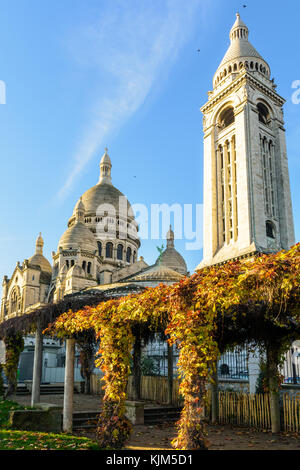 Les trois-quarts vue arrière de la Basilique du Sacré Coeur de Paris au lever du soleil en automne vu à partir d'un jardin public avec l'une pergola dans le foregro Banque D'Images