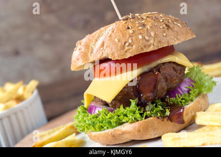 Cheeseburger avec frites et viande de boeuf sur la table en bois Banque D'Images