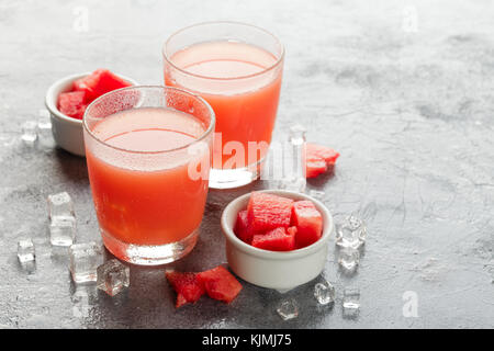 Watermelon drink avec de la glace dans des verres sur fond de béton gris Banque D'Images