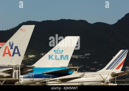 Queue d'avions de palmes, d'un B757 d'American Airlines, KLM et Air France B747 A340 à la suite, sur le terrain, à l'aéroport de Sint Maarten, avec des collines derrière, en t Banque D'Images