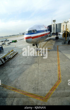 Pare-brise et le châssis du train avant d'un Boeing 777-200 stationné avec inductance et d'un attelage avec American Airlines à jetway Gate A22 sur le marquage de l'aire Banque D'Images