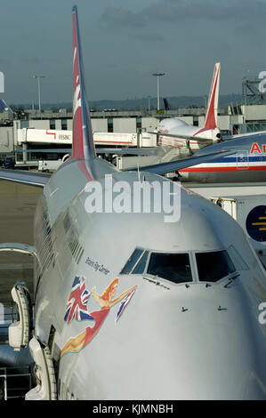 Virgin Atlantic Airways Boeing 747-400 à l'entrée à la borne3 avec un American Airlines 777-200 ER roulage et un avion d'Air India 747-400 garée derrière Banque D'Images