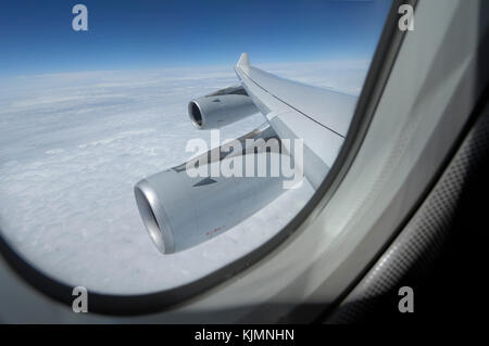 Fenêtre avec le moteur CFM56-5C2 de capots et de l'aile sur l'Airbus A340-300 de la Lufthansa voler au-dessus des nuages à numéro du vol LH737 NGO-FRA Banque D'Images