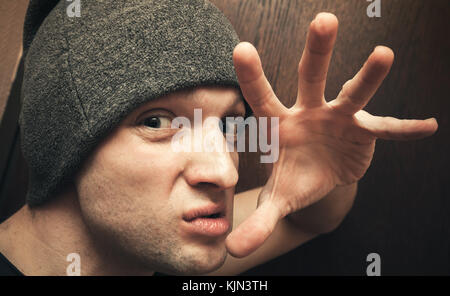 Jeune homme de race blanche agressive menace avec les doigts. close up studio face portrait, selective focus Banque D'Images