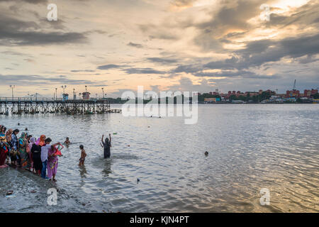 Les femmes indiennes prendre bain dans le Gange près de old jetty surplombant le pont vidyasagar. Banque D'Images