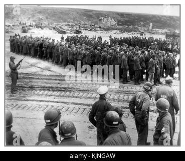 15 juin 1944 Omaha Beach Armée allemande les prisonniers militaires prisonniers de bateau attendent le passage vers le Royaume-Uni... L'Allemagne D-Day et la Wehrmacht Waffen SS prisonniers avec les troupes GI américain garde en premier plan Banque D'Images