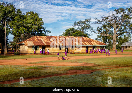 Kolonyi, Ouganda - 09 novembre 2017 : de nombreux étudiants avec uniforme violet attendent d'entrer dans l'école primaire de kolonyi près de Mbale en Ouganda sur une beauti Banque D'Images