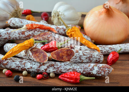 Des salametti, minces, petits saucissons à l'extérieur du moule noble, chaud et épicé, parfait avec du vin ou de la bière ; close up side view, décoré de chi à sec Banque D'Images