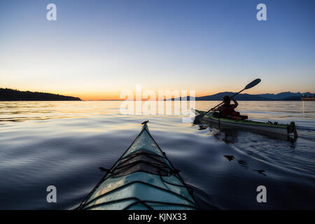 Kayak de mer dans l'océan lors d'un coucher de soleil colorés et dynamiques. prises à Jéricho, Vancouver, Colombie-Britannique, Canada. Banque D'Images