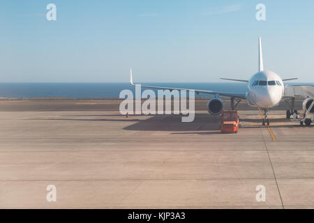 L'avant du comité permanent de l'avion sur la piste de fond de l'océan Banque D'Images