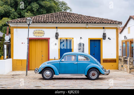 Maison coloniale jaune, bleu coccinelle Volkswagen, rue pavée, Tiradentes, Minas Gerais, Brésil. Banque D'Images