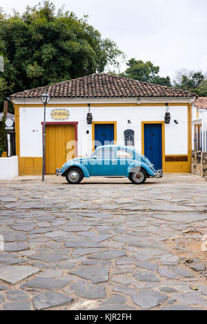 Maison coloniale jaune, bleu coccinelle Volkswagen, rue pavée, Tiradentes, Minas Gerais, Brésil. Banque D'Images