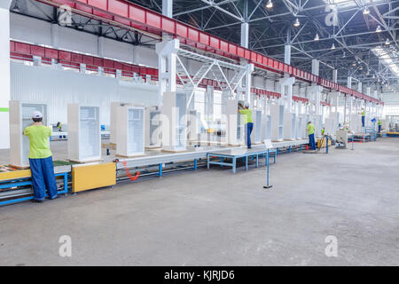 Sol de l'usine pour la production et l'assemblage des réfrigérateurs sur le convoyeur à bande. Les ouvriers d'usine collecter des réfrigérateurs sur le convoyeur à bande Banque D'Images