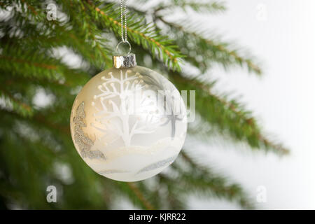 Décorations de Noël, une boule blanche accroché sur l'arbre de Noël Banque D'Images