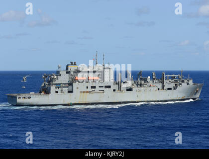 Un MH-60 de la Marine américaine d'hélicoptères Seahawk cargo offre sur la marine américaine Lewis et Clark-classe de marchandises et de munitions ship USNS Carl Brashear 20 novembre 2017 dans l'océan Pacifique. (Photo de Jose Madrigal par Planetpix) Banque D'Images