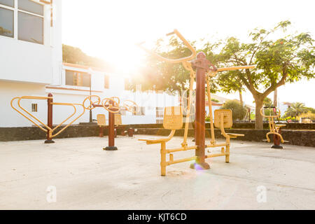 Une aire de jeux publique dans une petite ville d'Espagne avec des appareils de fitness de plein air au coucher du soleil Banque D'Images