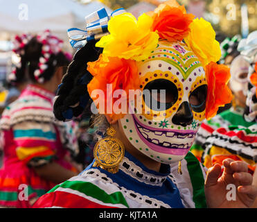 Girl wearing colorful crâne masque et fleurs en papier pour le dia de los muertos/Jour des morts à San Antonio, TX Banque D'Images