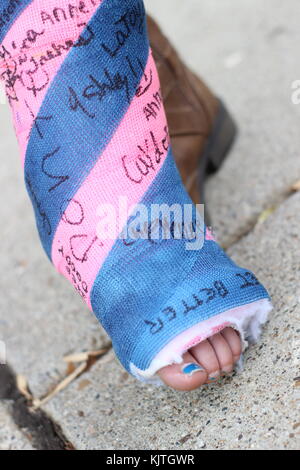 Près d'un petit enfant avec le pied et la cheville avec signatures, rose et bleu Banque D'Images