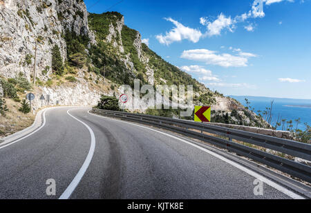 La route d'asphalte de la mer. autoroute asphalte dans une journée ensoleillée à l'extérieur de la ville en passant par la falaise à côté de la mer. Banque D'Images