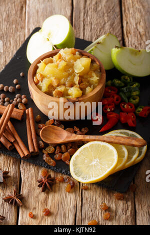 Chutney de pommes maison avec des raisins secs et d'épices close-up dans un bol sur la table verticale. Banque D'Images