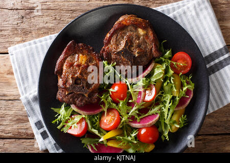 L'agneau rôti de boeuf épicé et radis salade, tomate et laitue close-up sur une plaque horizontale. haut Vue de dessus Banque D'Images