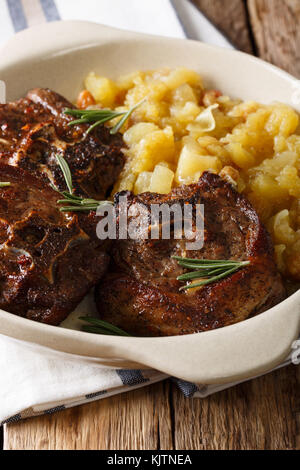 Steak d'agneau au romarin et chutney de pommes close-up dans un bol sur la table verticale. Banque D'Images