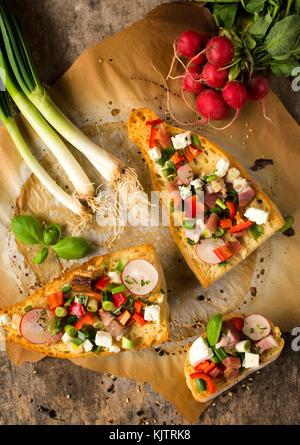 Fromage et légumes savoureux bruschettas sur la table,d'en haut Banque D'Images