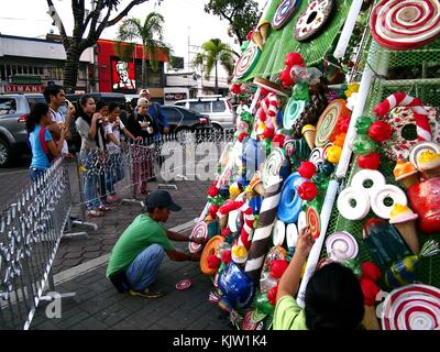 Antipolo City, Philippines - 25 novembre 2017 : les travailleurs Décorer un sapin de noël géant dans un parc public avec des matériaux recyclés. Banque D'Images