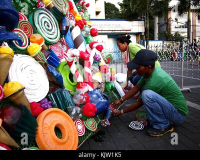 Antipolo City, Philippines - 25 novembre 2017 : les travailleurs Décorer un sapin de noël géant dans un parc public avec des matériaux recyclés. Banque D'Images