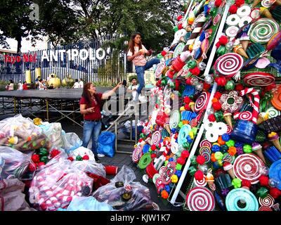 Antipolo City, Philippines - 25 novembre 2017 : les travailleurs Décorer un sapin de noël géant dans un parc public avec des matériaux recyclés. Banque D'Images