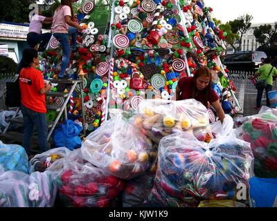 Antipolo City, Philippines - 25 novembre 2017 : les travailleurs Décorer un sapin de noël géant dans un parc public avec des matériaux recyclés. Banque D'Images