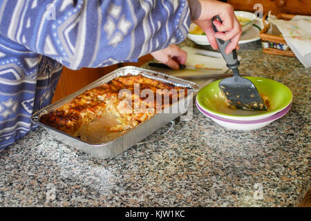 Young caucasian woman la préparation de plats de pâtes italiennes lasagne faite maison sur la table. Version de la viande. Florence, Italie. Saison d'hiver. Banque D'Images