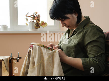 Les femmes brodent sur cadre de broderie (point de croix) Banque D'Images