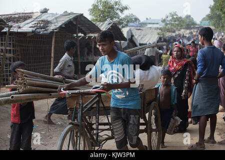 23 novembre 2017 - Cox's Bazar, Bangladesh - Un jeune Rohingya pousse un vélo plein de matériaux de construction dans les rues de Kutupalong. Le camp de réfugiés de Kutupalong est un camp de réfugiés situé à Ukhia dans la région de Cox's Bazar au Bangladesh, il fournit principalement des éclats pour les musulmans rohingyas qui ont fui la persécution religieuse au Myanmar. Le HCR a estimé qu'il y avait au moins 30 000 réfugiés dans le camp à la fin de 2017. Crédit : Marcus Valance/SOPA/ZUMA Wire/Alamy Live News Banque D'Images