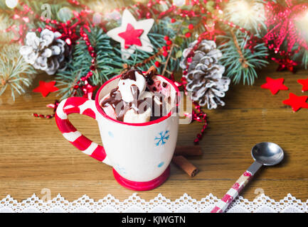 Guimauves colorés avec du chocolat dans une tasse avec des décorations de fête Banque D'Images