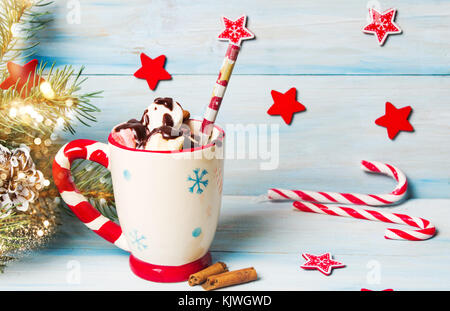 Guimauves colorés avec du chocolat dans une tasse avec des décorations de fête Banque D'Images