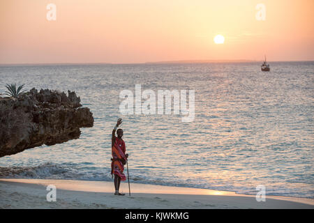 Zanzibar, Tanzanie ; les jeunes guerriers Massaïs sur la plage pour vendre bijoux Massaï et de l'artisanat traditionnel de leur cage à proximité pour les touristes à la plage hôtels dans le nord de l'île. Banque D'Images