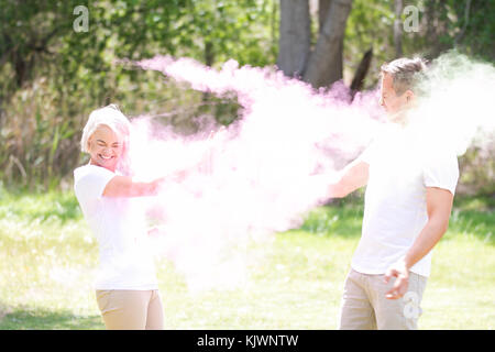 Jeune couple funky à jouer avec de l'eau colorée de la peinture sur le festival holi Banque D'Images