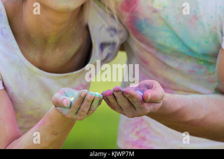 Jeune couple funky à jouer avec de l'eau colorée de la peinture sur le festival holi Banque D'Images