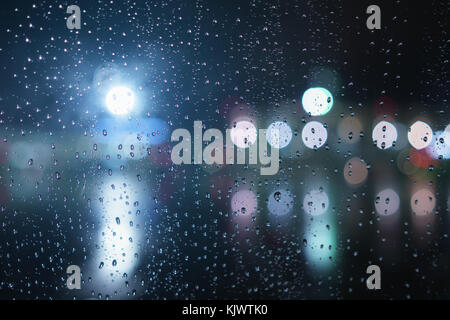 Libre des gouttes sur la fenêtre dans la nuit avec des lumières Banque D'Images