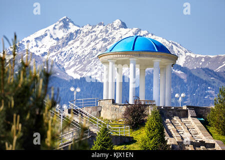 Monument avec colonne à fond les montagnes enneigées dans le parc de n premiers Almaty, Kazakhstan Banque D'Images