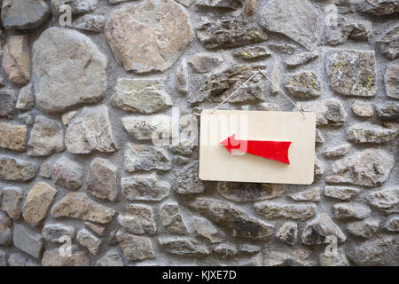 Flèche en bois rouge accroché au mur panneau pour vos besoins. Panneau en bois rouge. Banque D'Images