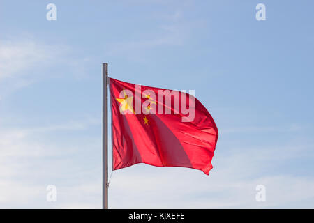 Drapeau chinois en fond de ciel bleu vif, drapeau rouge avec étoile jaune battant en été , vent soufflant du pavillon des ressortissants chinois. Banque D'Images