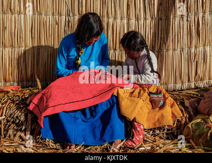 Les filles autochtones uro l'artisanat, les îles flottantes des Uros, lac Titicaca, région de Puno, Pérou Banque D'Images