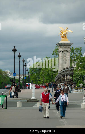 Les touristes de passage le Pont Alexandre III historique pont qui franchit la Seine à Paris décoré avec de belles lampes, chérubins, des statues de nymphes Banque D'Images