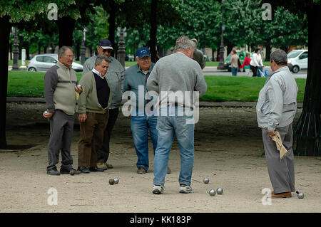 Les hommes âgés dans un parc public à Paris lors d'une partie de pétanque jeter la metal europeen pour les obtenir le plus près possible de balle en bois appelé jack Banque D'Images